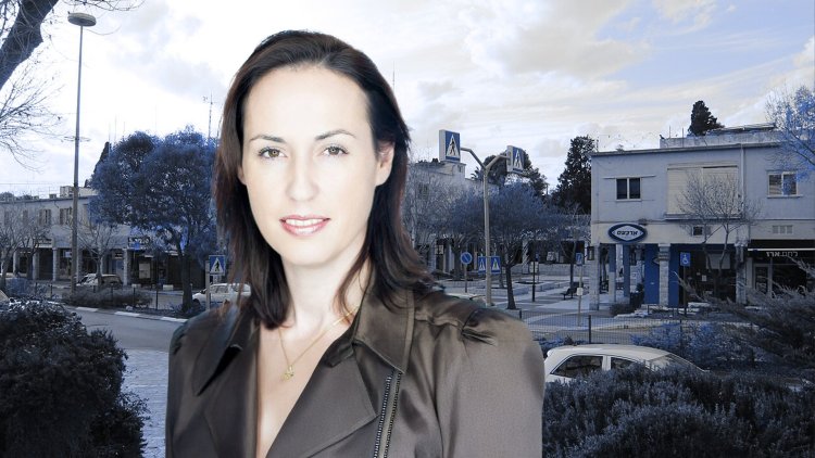 מהנדסת קריית טבעון היוצאת אסנת ברש על רקע מרכז המועצה (שגיב אהרון, Jakednb, ויקימדיה)