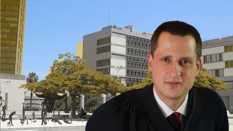השופט גיא הימן על רקע בית משפט השלום בתל אביב (Sambach, ויקימדיה, אתר הרשות השופטת)